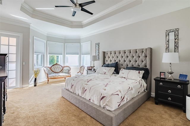 bedroom featuring a raised ceiling, ceiling fan, light carpet, and crown molding