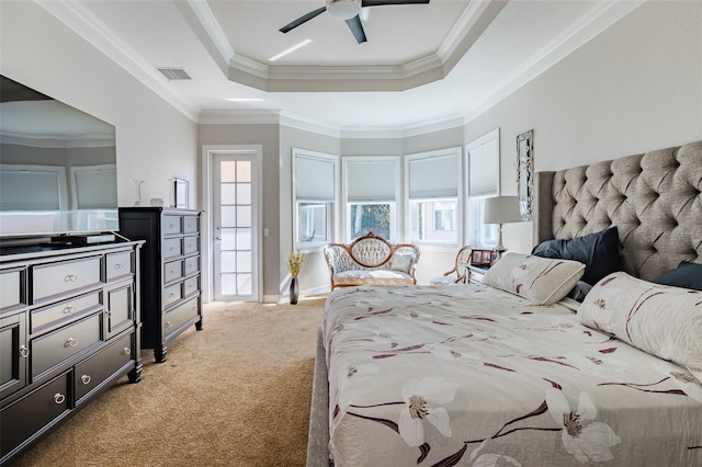 bedroom with ceiling fan, crown molding, carpet floors, and a tray ceiling