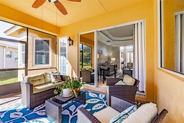 sunroom / solarium with ceiling fan, a wealth of natural light, and a raised ceiling