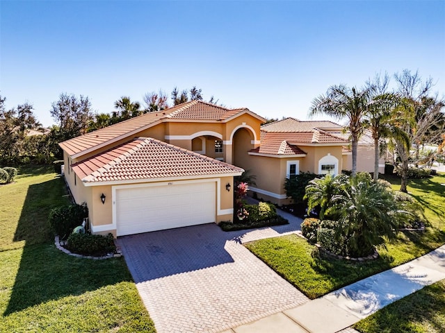 mediterranean / spanish-style house featuring a front yard and a garage