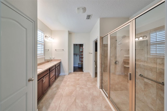 bathroom with vanity, tile patterned floors, toilet, a textured ceiling, and a shower with shower door