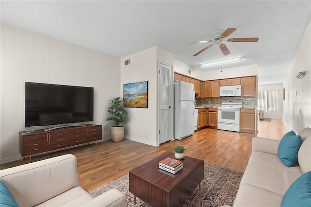 living room featuring light hardwood / wood-style floors and ceiling fan