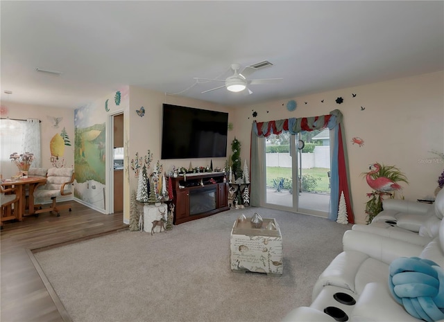 living room with ceiling fan, a fireplace, and wood-type flooring