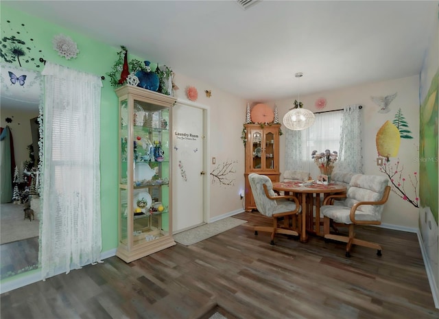 dining space with dark hardwood / wood-style floors and a chandelier