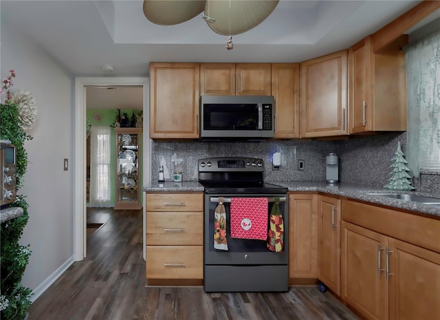 kitchen featuring dark hardwood / wood-style flooring, electric range, tasteful backsplash, and a raised ceiling