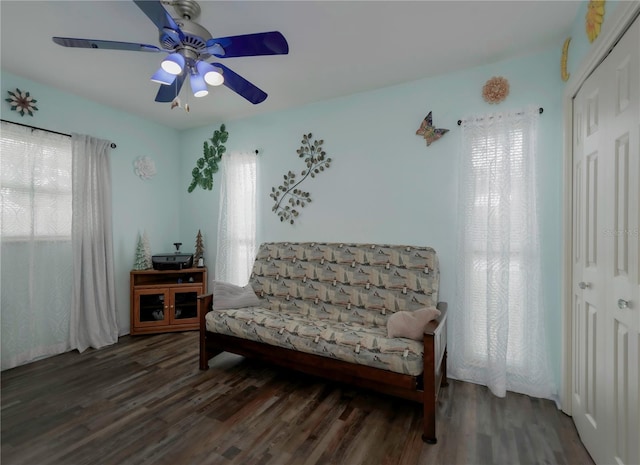 living area with ceiling fan and dark hardwood / wood-style floors