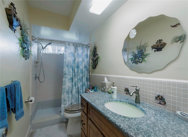 bathroom featuring vanity, toilet, walk in shower, and tile walls