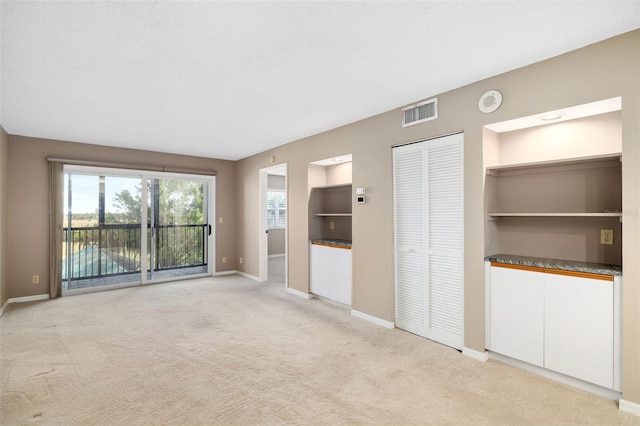 unfurnished room featuring light colored carpet