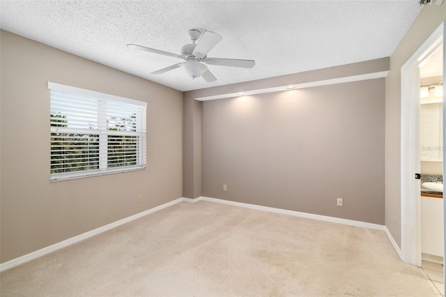 carpeted empty room featuring ceiling fan and a textured ceiling