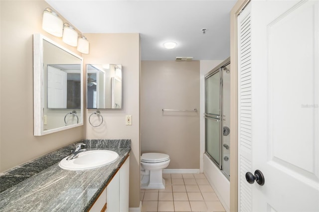 full bathroom featuring tile patterned flooring, vanity, toilet, and shower / bath combination with glass door