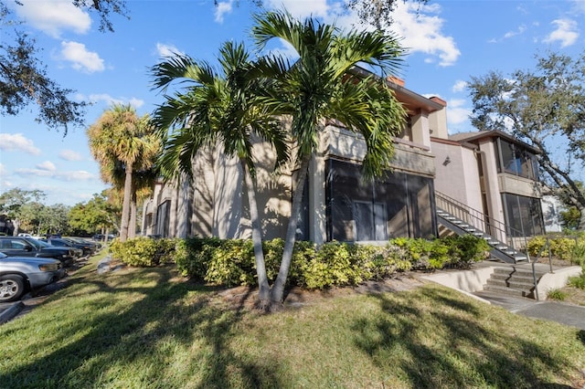 10265 Gandy Blvd N Unit 905, Saint Petersburg, FL 33702 - view of property exterior featuring stairs, a yard, and stucco siding