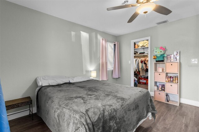 10265 Gandy Blvd N Unit 905, Saint Petersburg, FL 33702 - bedroom featuring wood finished floors, a walk in closet, baseboards, a closet, and a ceiling fan