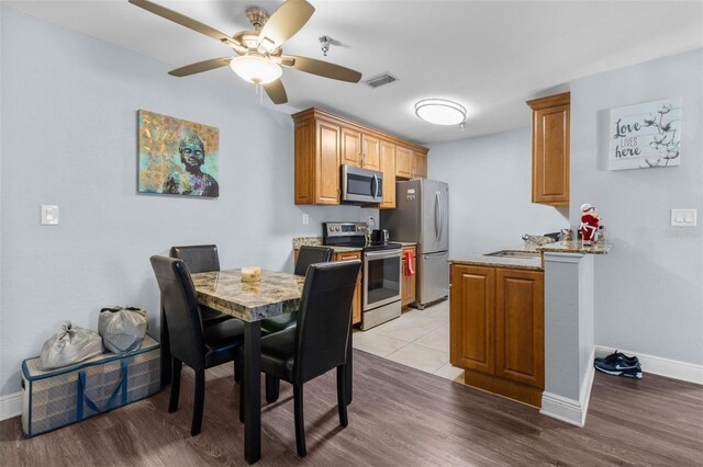 10265 Gandy Blvd N Unit 905, Saint Petersburg, FL 33702 - kitchen with stainless steel appliances, baseboards, ceiling fan, and light wood-type flooring
