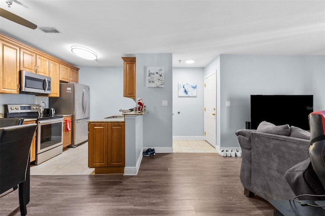 kitchen with light hardwood / wood-style floors, sink, and stainless steel appliances