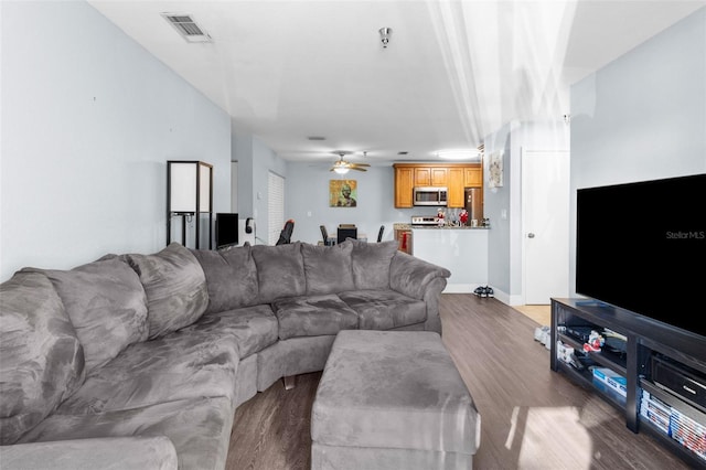 living room with dark hardwood / wood-style flooring and ceiling fan