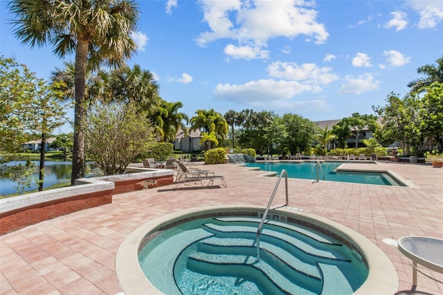 pool featuring a water view, a patio area, and a community hot tub