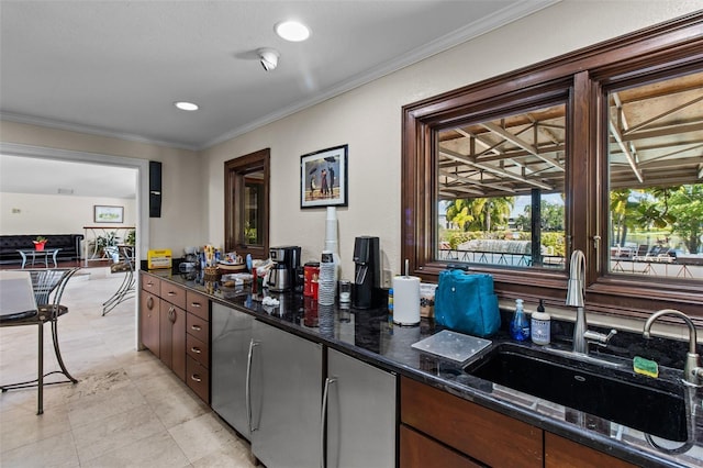 kitchen with dark stone countertops, ornamental molding, sink, and dark brown cabinetry