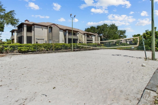 view of community featuring fence and volleyball court