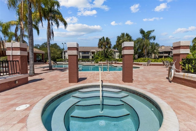 pool with a community hot tub and a patio