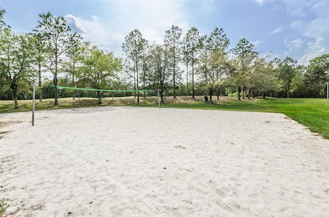 surrounding community with a lawn and volleyball court