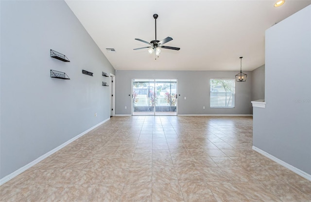 unfurnished room featuring light tile patterned floors, high vaulted ceiling, ceiling fan with notable chandelier, visible vents, and baseboards