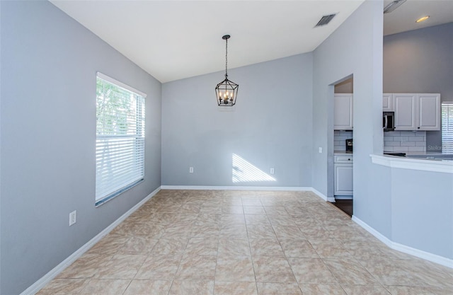 interior space featuring lofted ceiling, baseboards, visible vents, and a notable chandelier