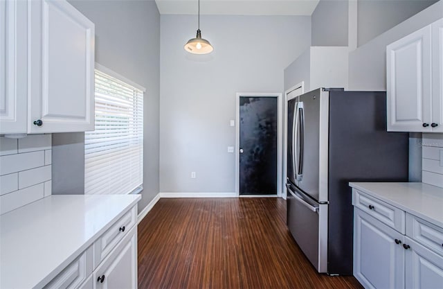 kitchen with white cabinetry, light countertops, dark wood-style flooring, and freestanding refrigerator