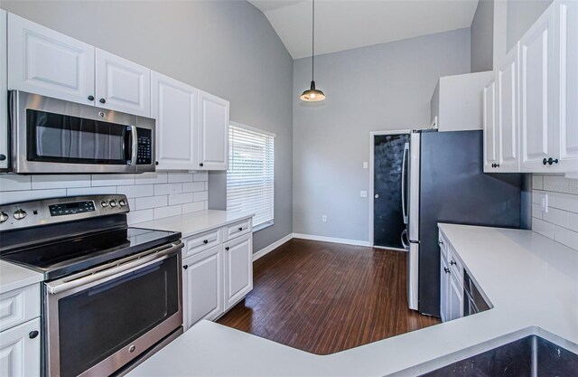 kitchen with white cabinets, stainless steel appliances, light countertops, and lofted ceiling