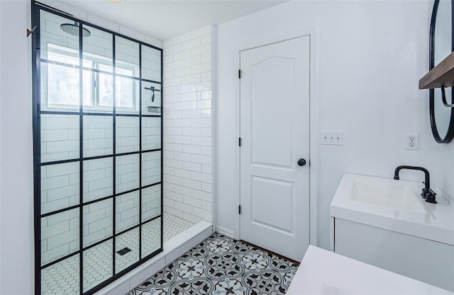 bathroom featuring tiled shower and vanity