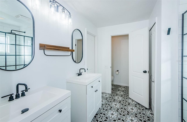 bathroom with two vanities, a sink, a shower stall, and toilet