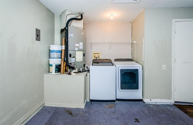 clothes washing area featuring heating unit, laundry area, washing machine and dryer, and baseboards