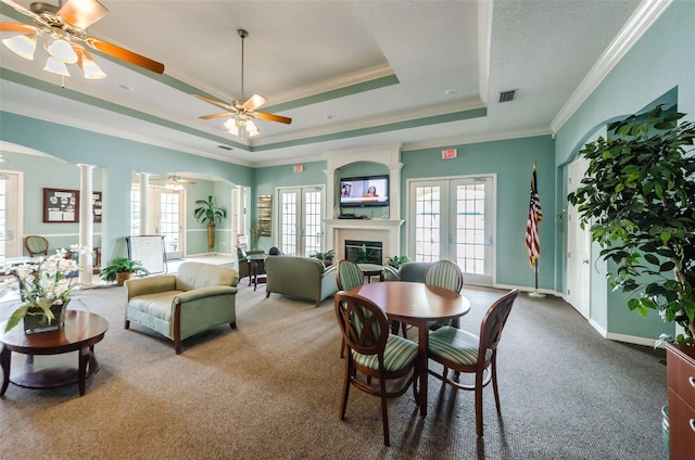 dining space featuring visible vents, carpet, a tray ceiling, french doors, and ornate columns