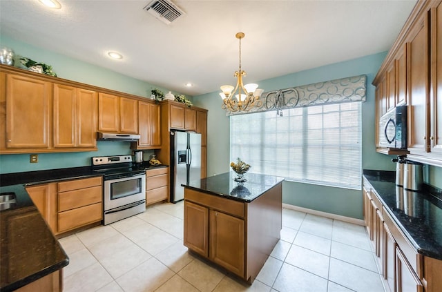 kitchen featuring stainless steel appliances, visible vents, hanging light fixtures, a kitchen island, and under cabinet range hood