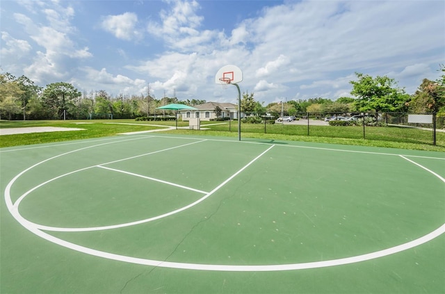 view of basketball court with community basketball court, fence, and a yard