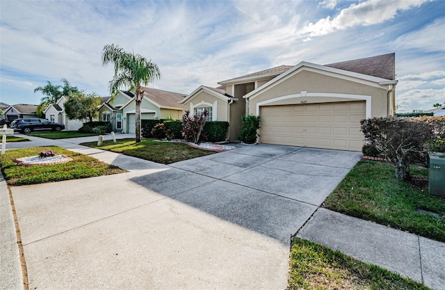 view of front of property featuring a front lawn, driveway, an attached garage, and stucco siding