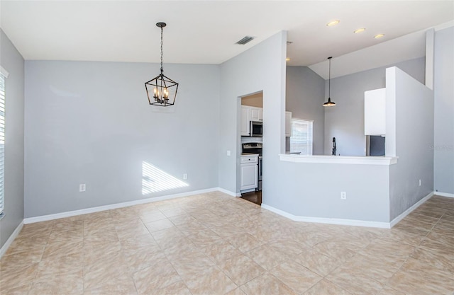 empty room with vaulted ceiling, visible vents, plenty of natural light, and baseboards