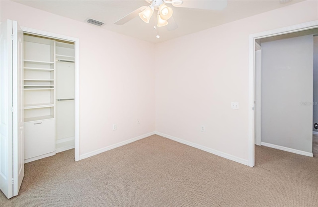 unfurnished bedroom with a ceiling fan, carpet flooring, visible vents, and baseboards