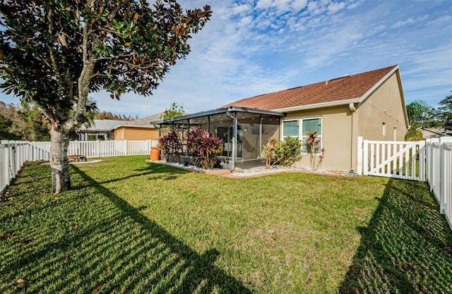 view of yard featuring a sunroom and a fenced backyard