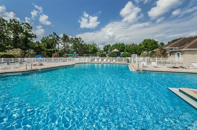 community pool featuring a patio area and fence