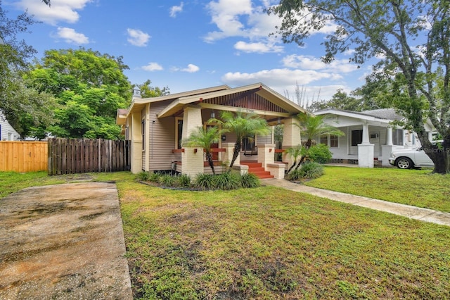 bungalow-style home featuring covered porch and a front lawn