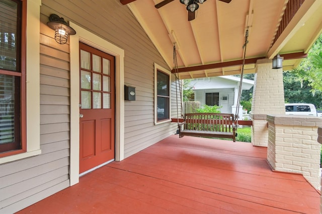 wooden terrace with covered porch and ceiling fan