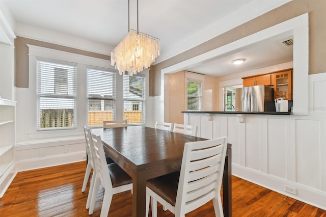 dining area featuring a chandelier, dark hardwood / wood-style floors, and a healthy amount of sunlight