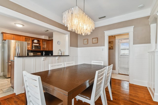 dining area featuring wood-type flooring and an inviting chandelier