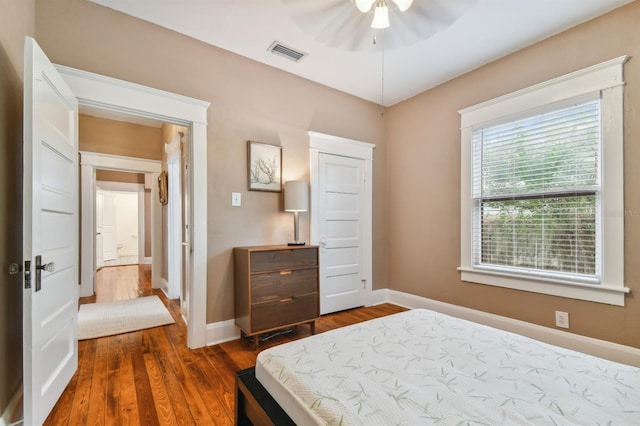 bedroom with dark hardwood / wood-style flooring and ceiling fan