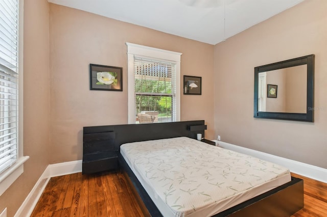 bedroom with dark hardwood / wood-style floors