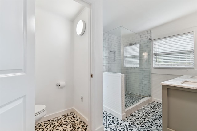 bathroom with tile patterned floors, vanity, walk in shower, and toilet