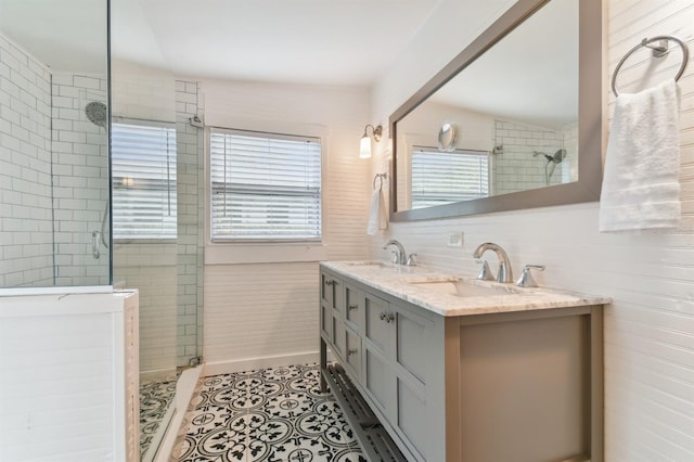 bathroom with tile patterned flooring, vanity, a tile shower, and vaulted ceiling