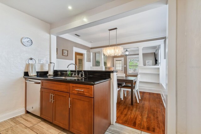 kitchen with dishwasher, sink, an inviting chandelier, pendant lighting, and light hardwood / wood-style floors