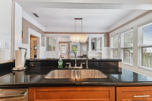 kitchen with a notable chandelier, dark stone countertops, sink, and decorative light fixtures