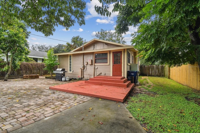 back of property featuring a wooden deck and a patio